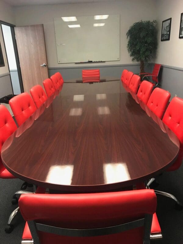 A large conference table with red chairs around it.